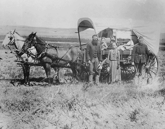 photograph of a family with their covered wagon during the Great Western Migration, 1866