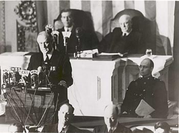 Three men seated around President Franklin D. Roosevelt giving speech