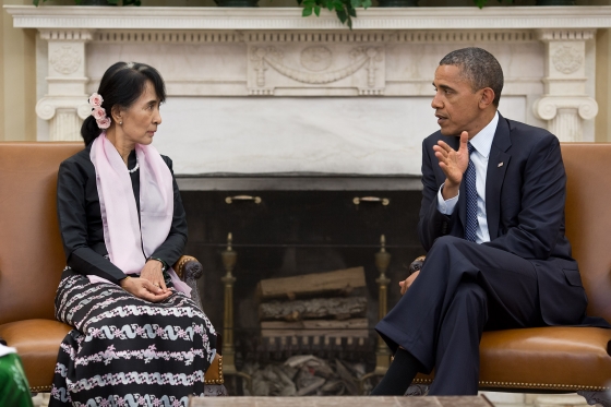 Aung San Suu Kyi talking with President Barack Obama in front of a fireplace.