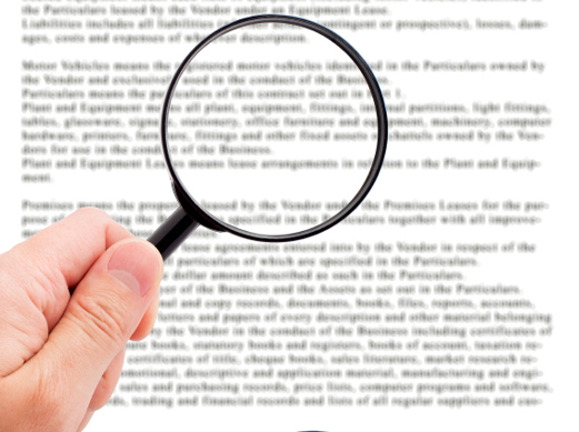 hands holding magnifying glasses over a document